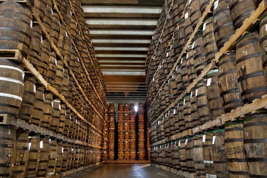 Oak casks stacked to the roof of a Caribbean rum warehouse